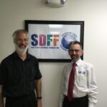 Two people in front of SDFF sign