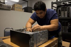 Picture of a man working on computer hardware with his hands in the foreground.